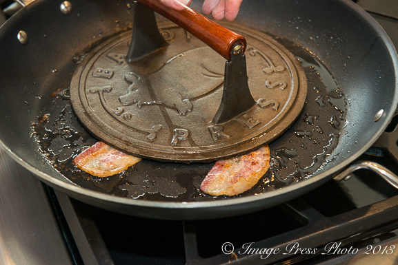 Use a bacon press to keep the bacon flat and even