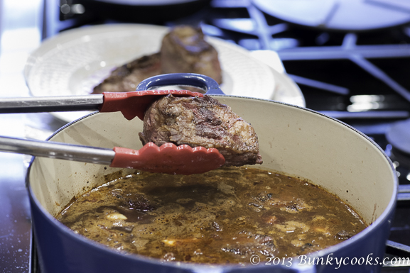 Place the short ribs back into the Dutch oven after all the other ingredients have been added