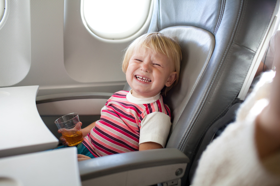 crying child with juice in airplane
